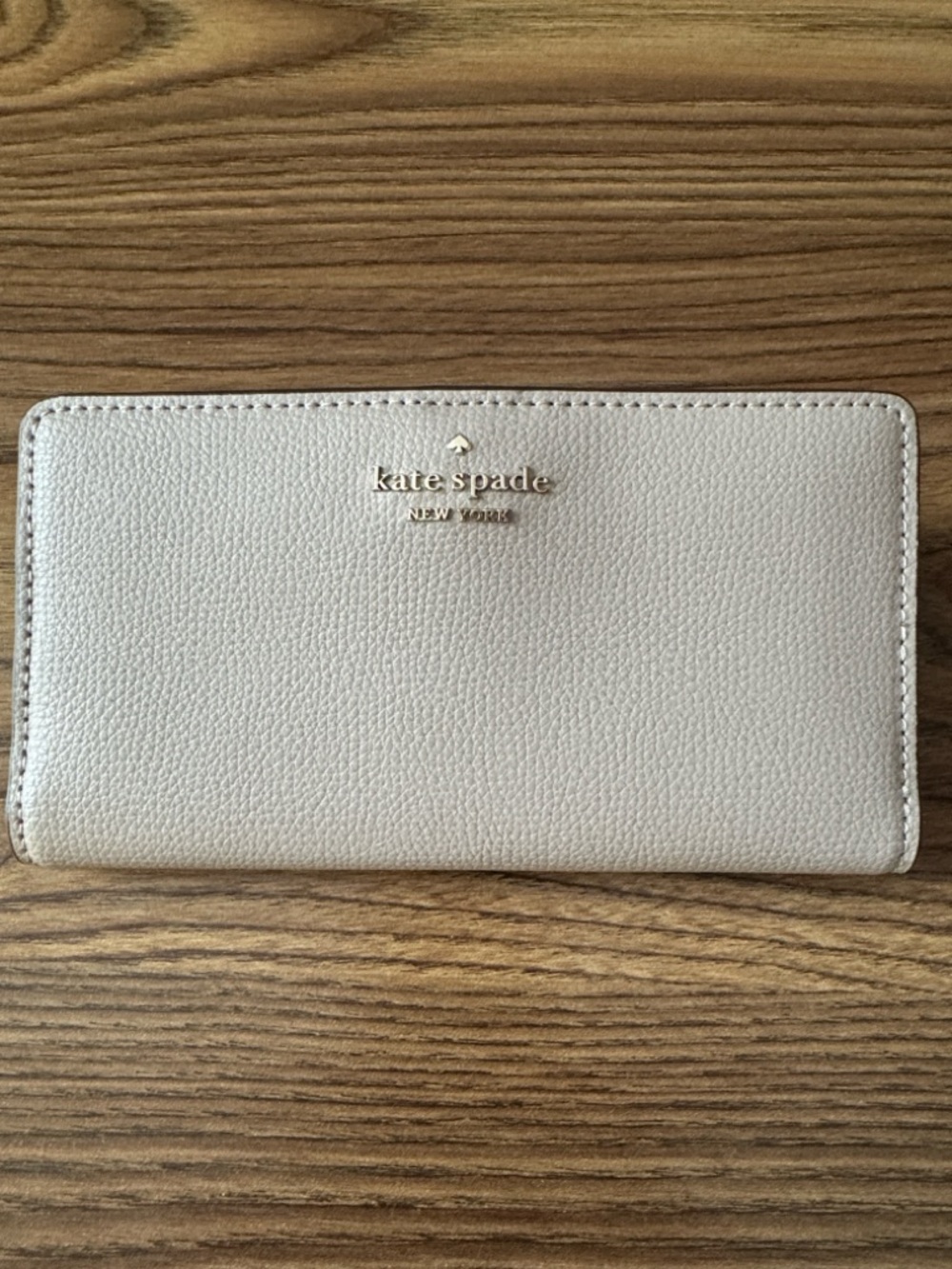 kate spade leather zip-around wallet in light gray with gold logo